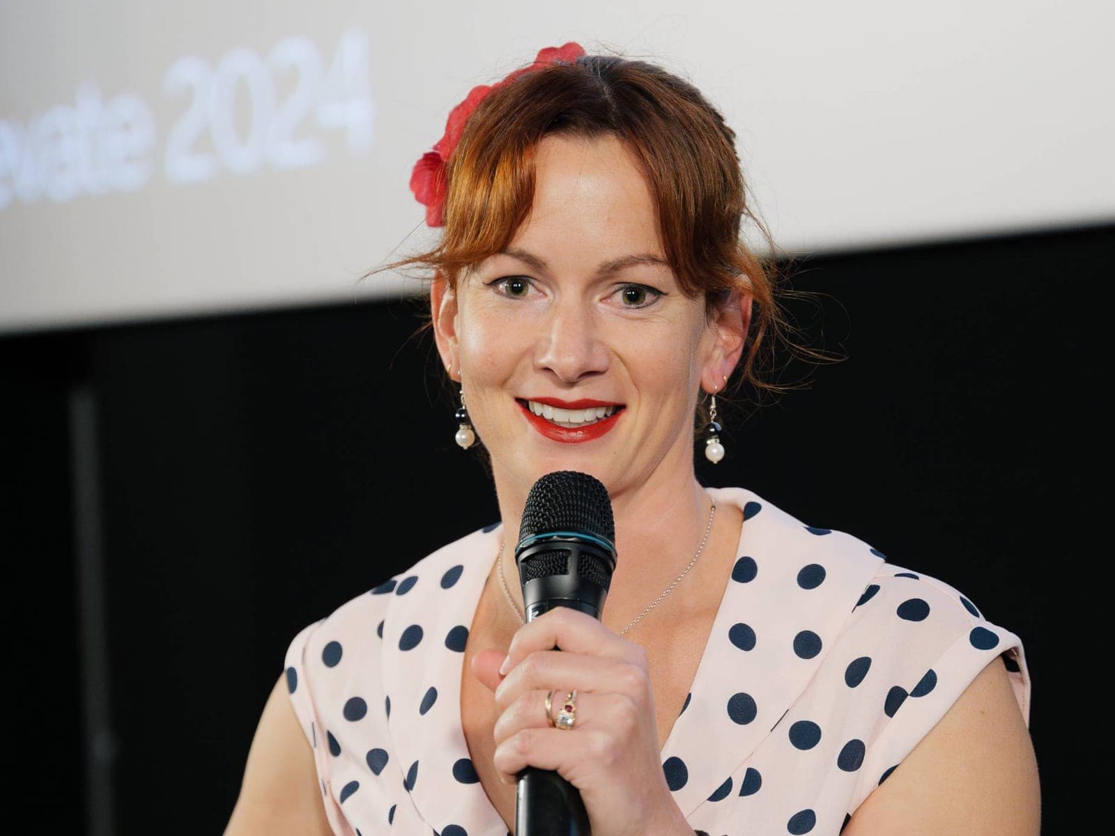 An event host, microphone in hand