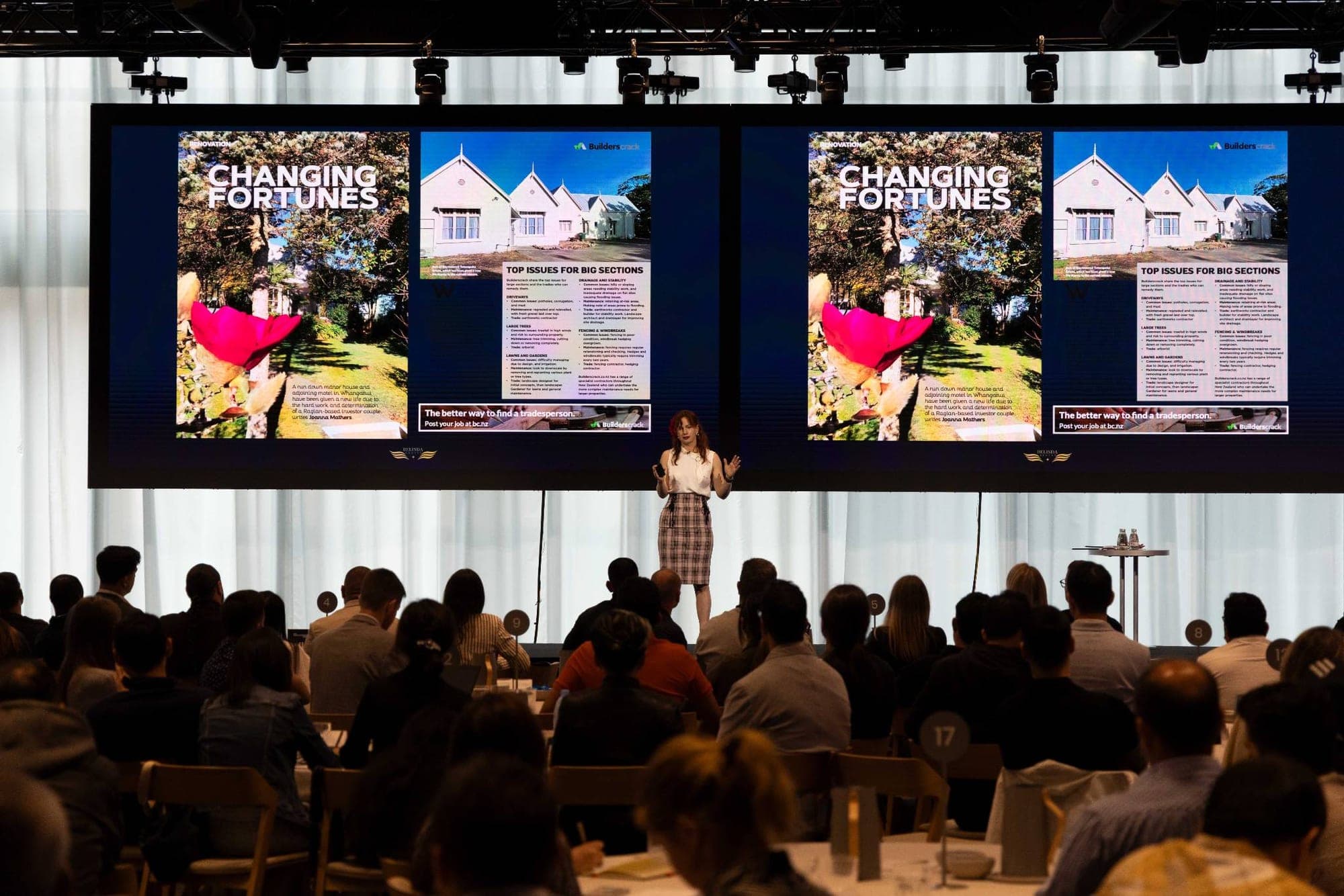 Steffanie Smith on stage teaching a room, property renovation case study on the screens behind her